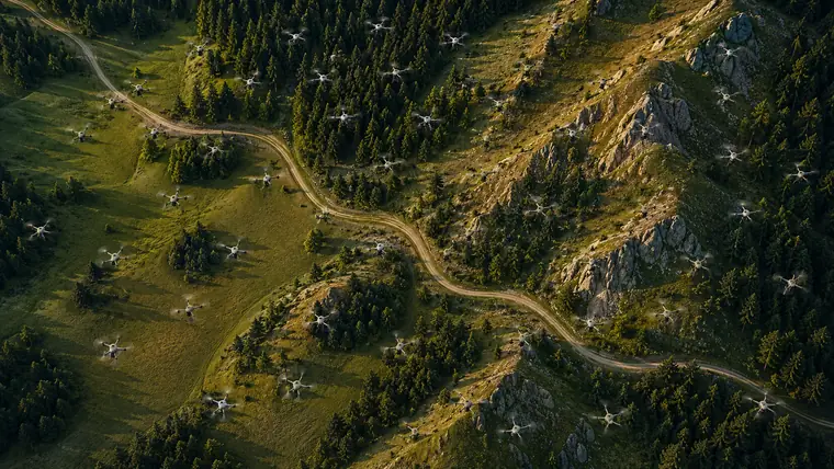Drone swarm flying in formation over a forested mountain valley